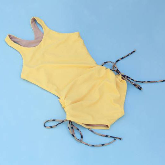 Yellow The Jane Shortie with leopard strings on a blue background.