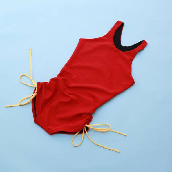 The Jane Shortie in Red/Love with Happy/yellow strings on a light blue background.
