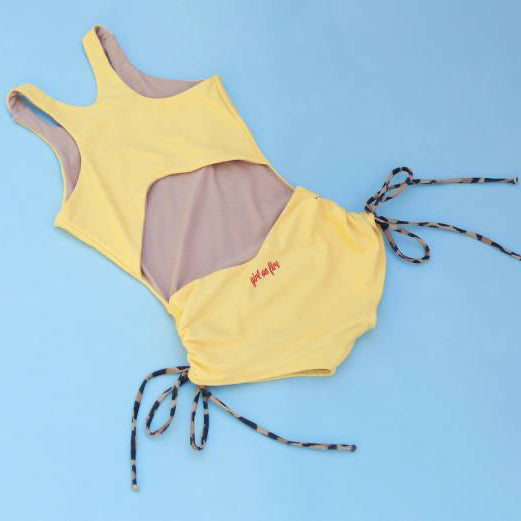 The Jane Bodysuit by Girl On Fire Artwear in Happy Yellow on a blue background